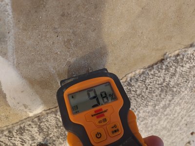 Moisture measurement — meter held against the floor