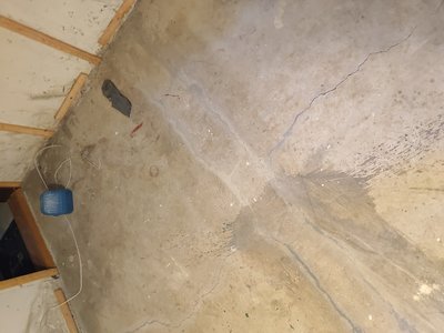 Basement room with visible debris and construction waste during cleanup