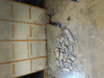 Damage and debris along basement wall